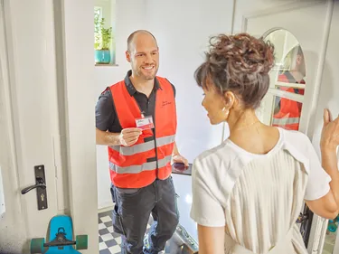 Ein Techniker zeigt Frau seinen Ausweis